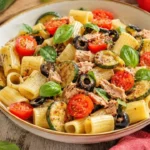 Pasta fredda con zucchine, tonno e pomodorini servita in un piatto colorato