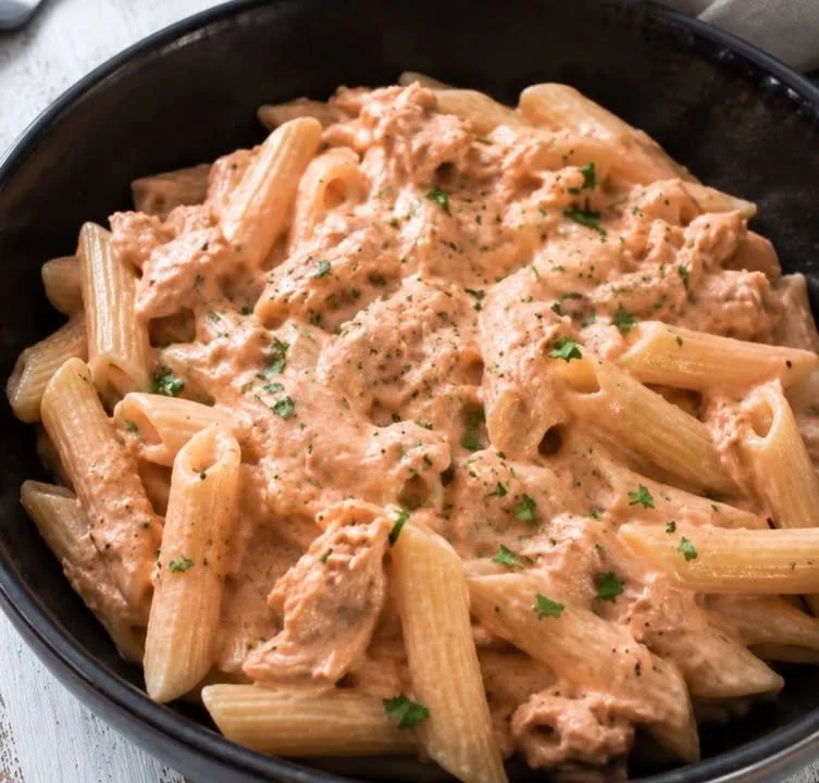 Penne al baffo con tonno pronto da servire su un piatto decorato