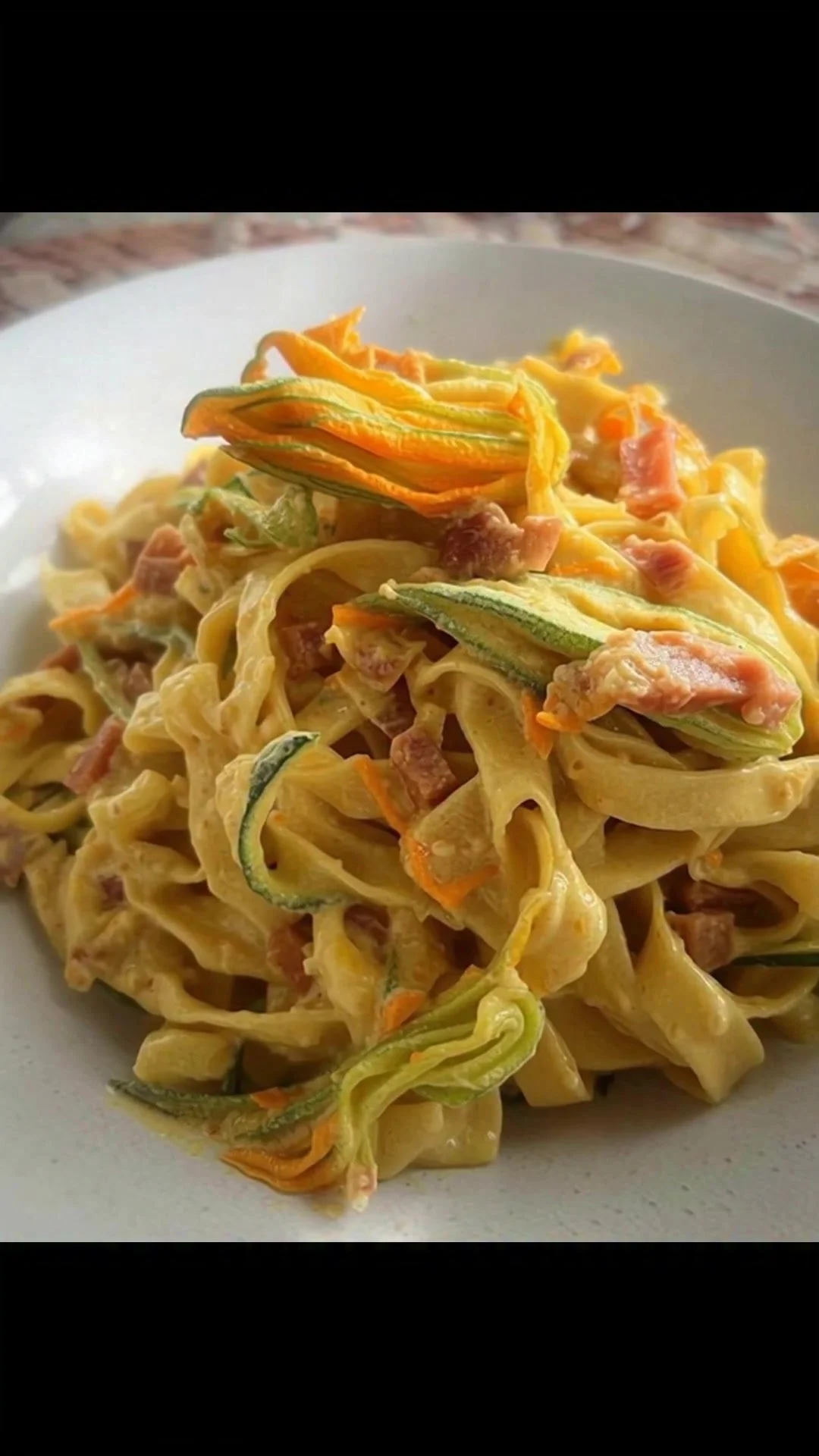 Tagliatelle con fiori di zucca e speck, piatto veloce pronto in 25 minuti.