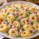Tortellini Panna Prosciutto e Piselli impiattati con crema e piselli freschi
